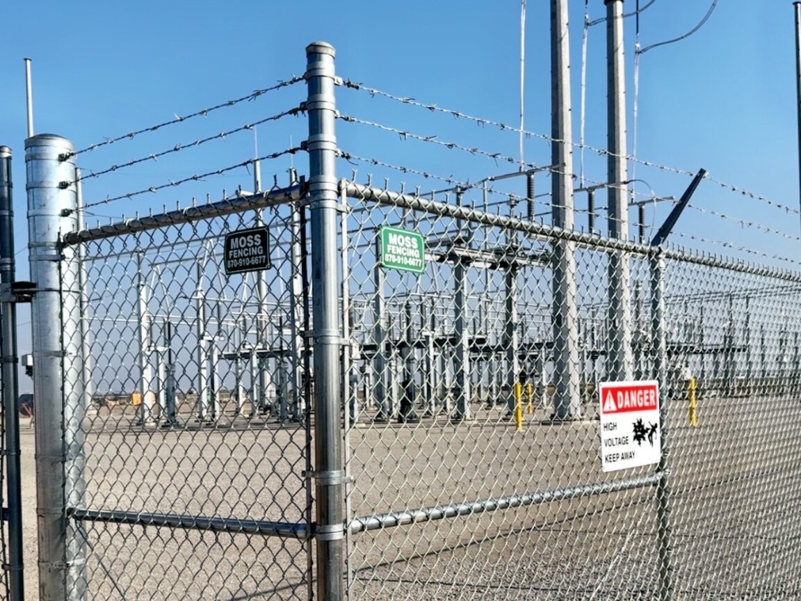 Commercial chain-link security gate with barbed wire
